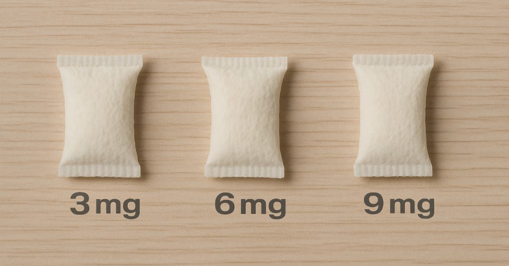 Three nicotine pouches labeled 3mg, 6mg, and 9mg on a wooden surface.