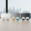 A professional product display of nicotine pouch cans categorized into Low, Medium, and High strength sections with a faint Dubai skyline background.