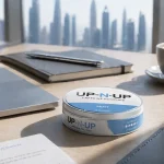 UP-N-UP caffeine pouch tin on office desk in Dubai with coffee cup in background